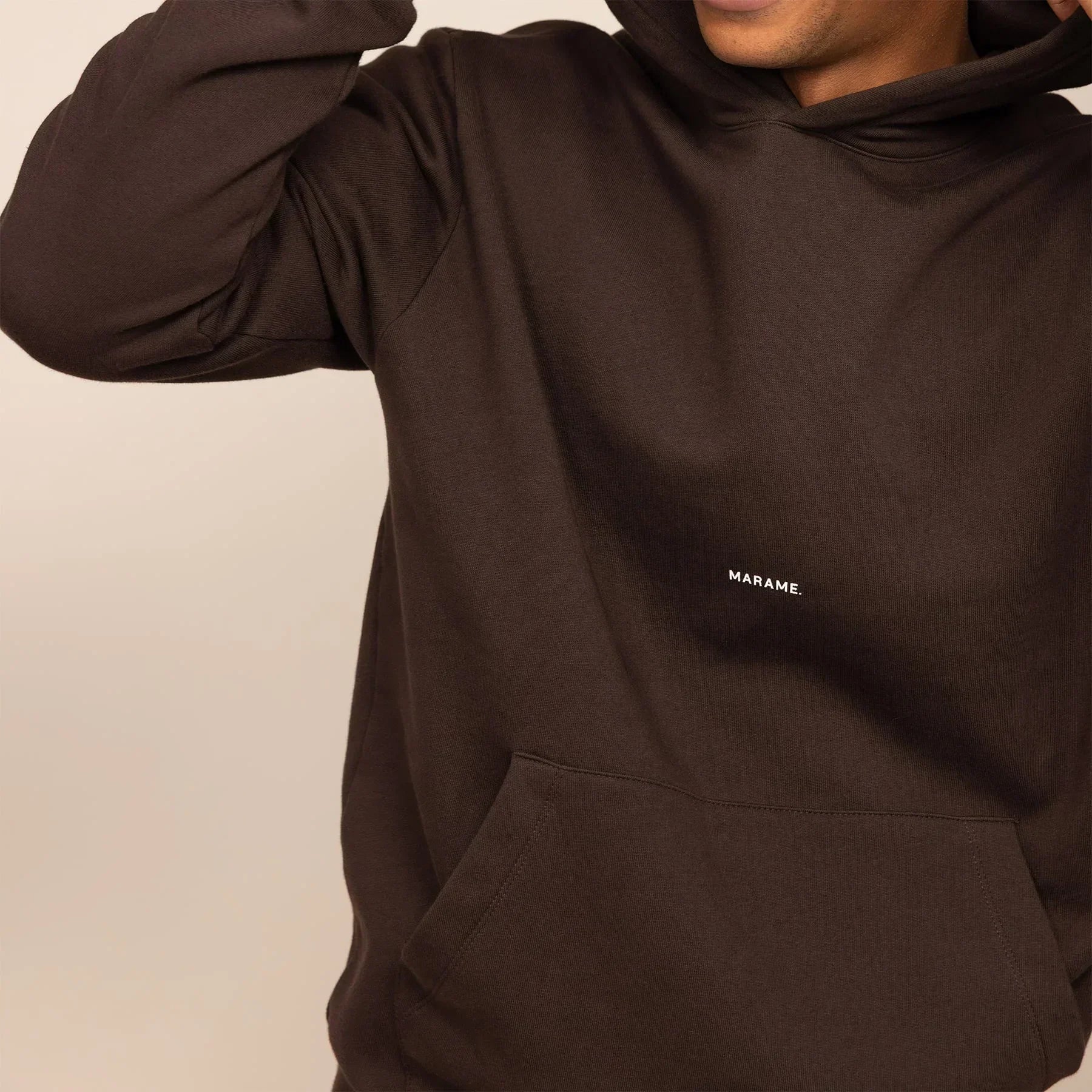 Man wearing a Marame cotton fleece Logo Hoodie in Smoked Brown, closeup|smoked brown