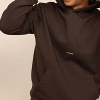 Man wearing a Marame cotton fleece Logo Hoodie in Smoked Brown, closeup|smoked brown