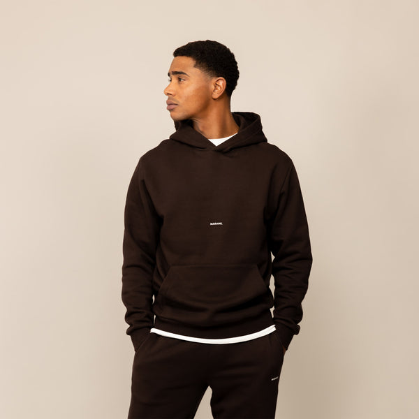 Man wearing a Marame cotton fleece Logo Hoodie in Smoked Brown, front view.
