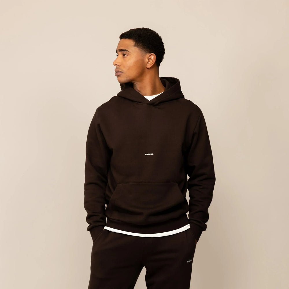 Man wearing a Marame cotton fleece Logo Hoodie in Smoked Brown, front view.|smoked brown