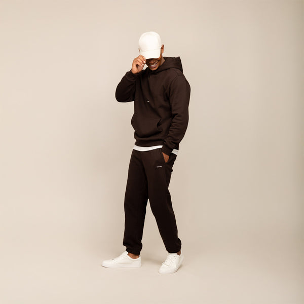 Man wearing a Marame cotton fleece Logo Hoodie in Smoked Brown, full view.