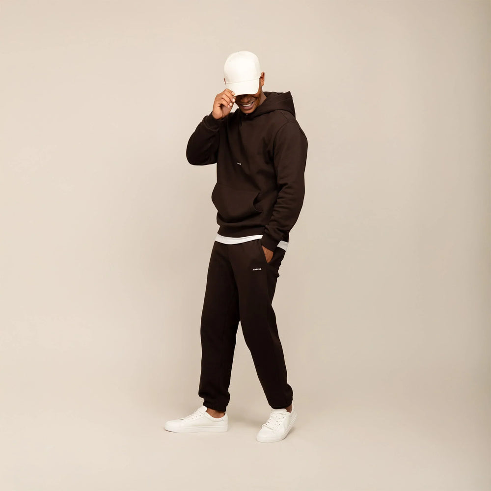 Man wearing a Marame cotton fleece Logo Hoodie in Smoked Brown, full view.