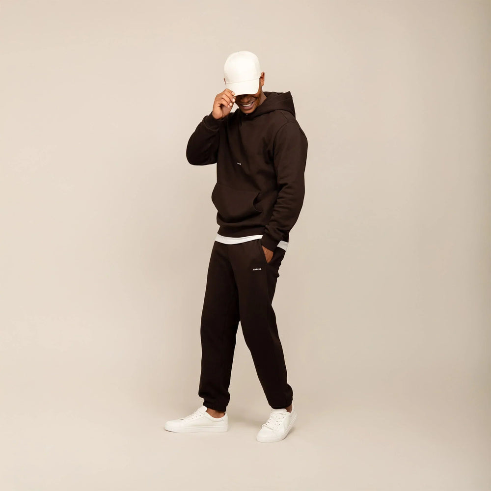 Man wearing a Marame cotton fleece Logo Hoodie in Smoked Brown, full view.|smoked brown
