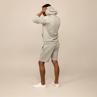 Man wearing a Marame cotton fleece Logo Hoodie in Wolf Grey, rear view.