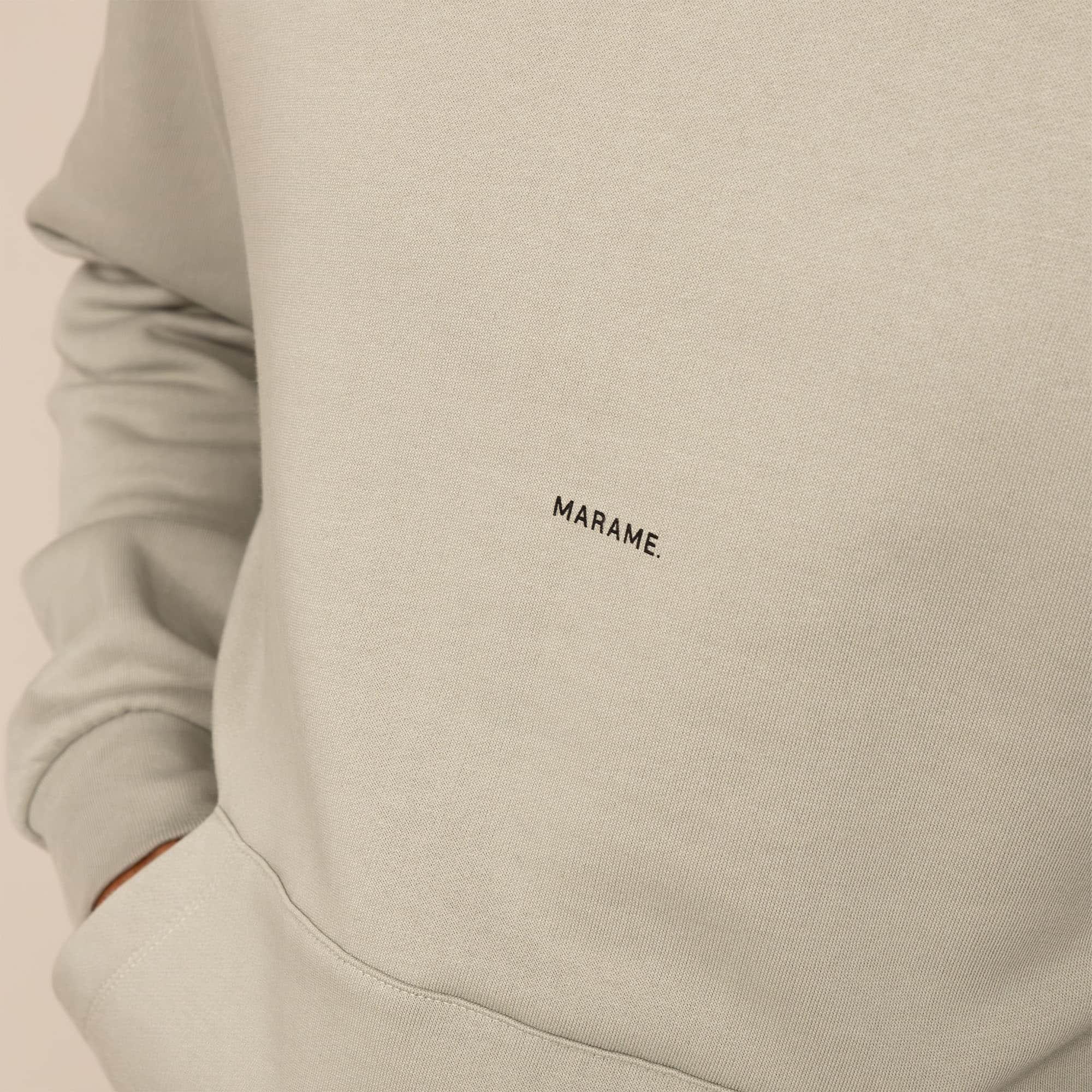 Man wearing a cotton fleece Logo Hoodie in Wolf Grey, closeup.|Wolf Green