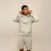 Man wearing a Marame cotton fleece Logo Hoodie in Wolf Grey, front view.