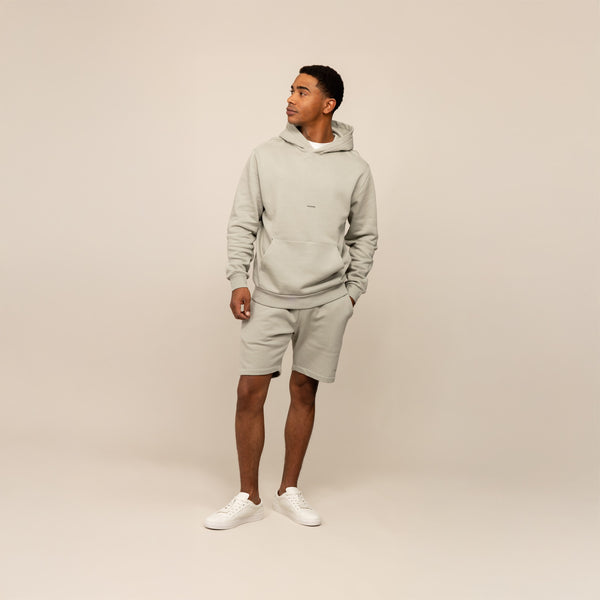 Man wearing a Marame cotton fleece Logo Hoodie in Wolf Grey, full view.
