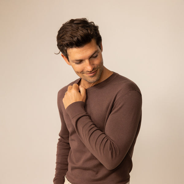 Man wearing a Marame Fine Knit Crew Neck Jumper in Conker Brown, front view.