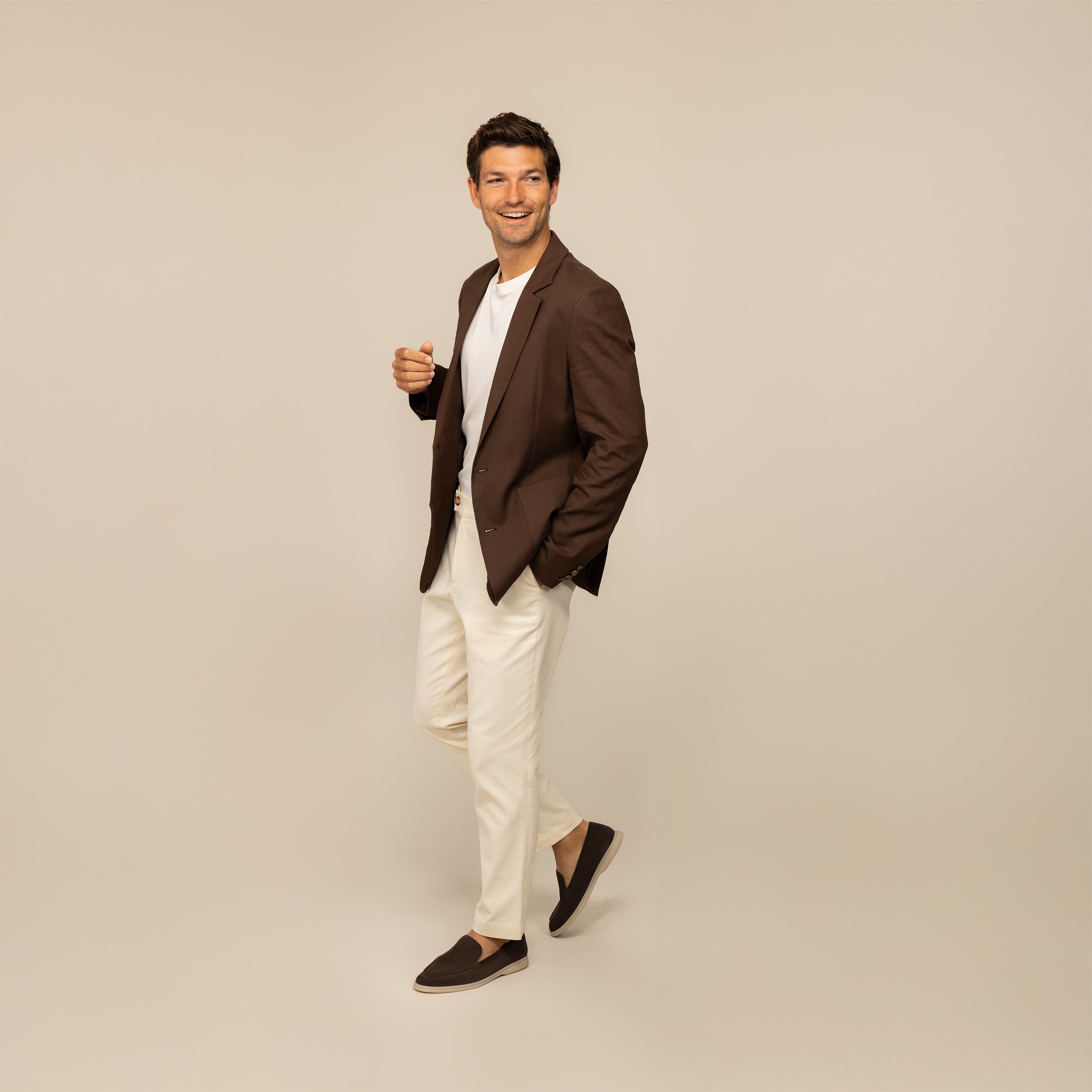 Men's holiday outfit inspiration featuring brown linen blazer, white T-shirt, beige linen trousers, and brown suede loafers by Marame