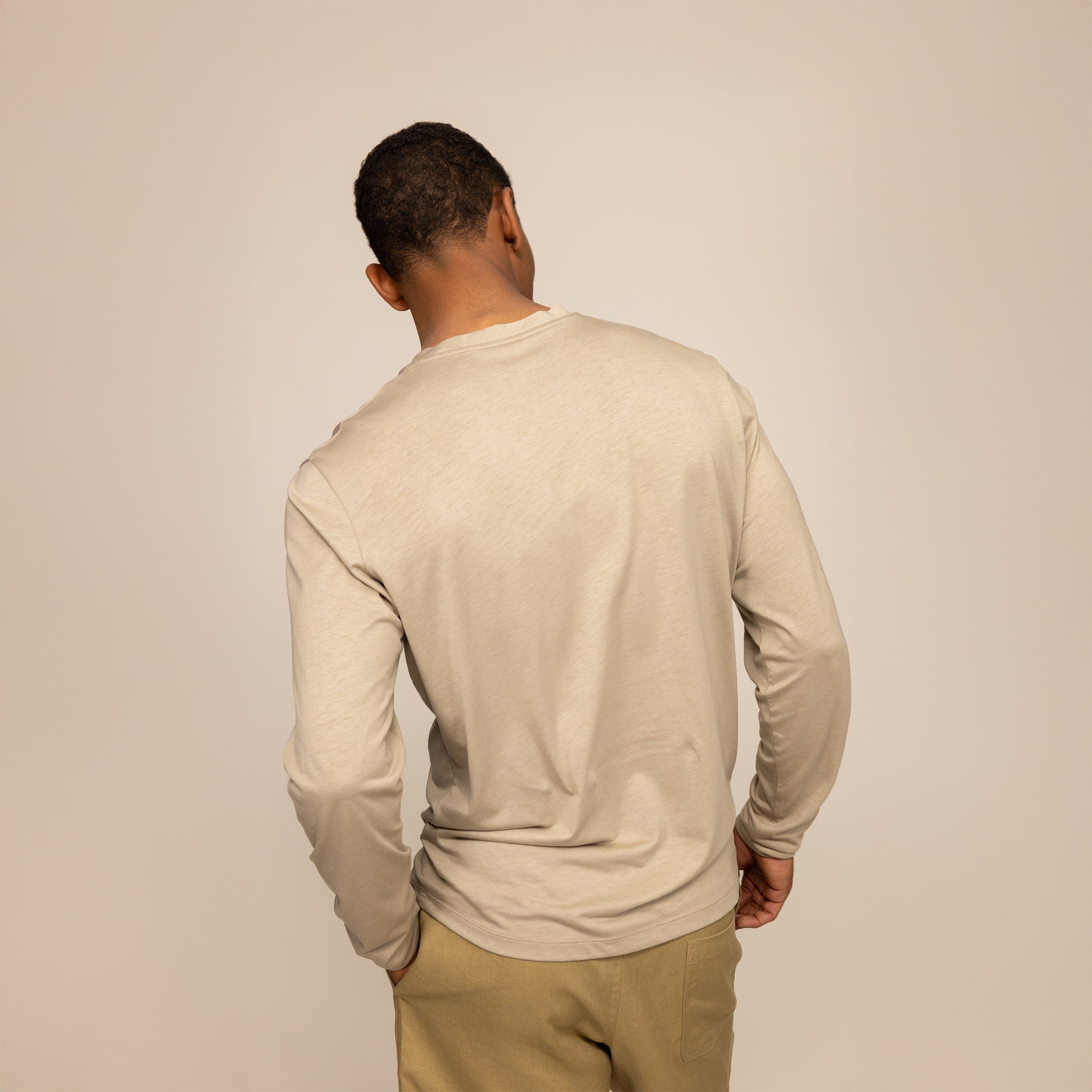 Man wearing a Long Sleeve Logo T-Shirt in Canyon Clay, rear view.