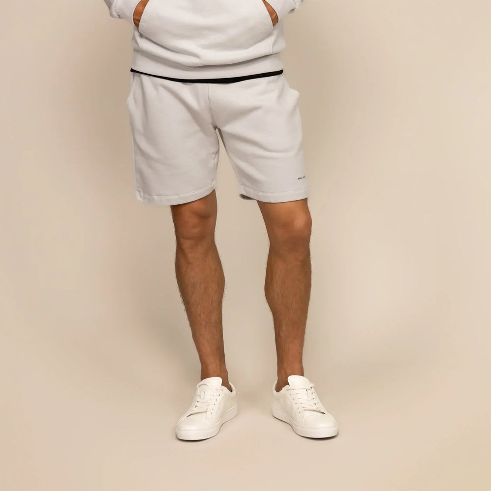 Man wearing Marame Lounge Shorts in Ash White, front view.