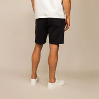 Man wearing Lounge Shorts in Black, rear view.