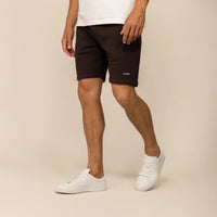 Man wearing Marame Lounge Shorts in Smoked Brown, front view.