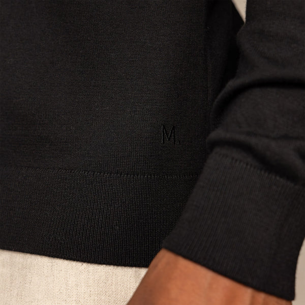 Man wearing a Merino Cotton Long Sleeve Polo in Black, closeup.