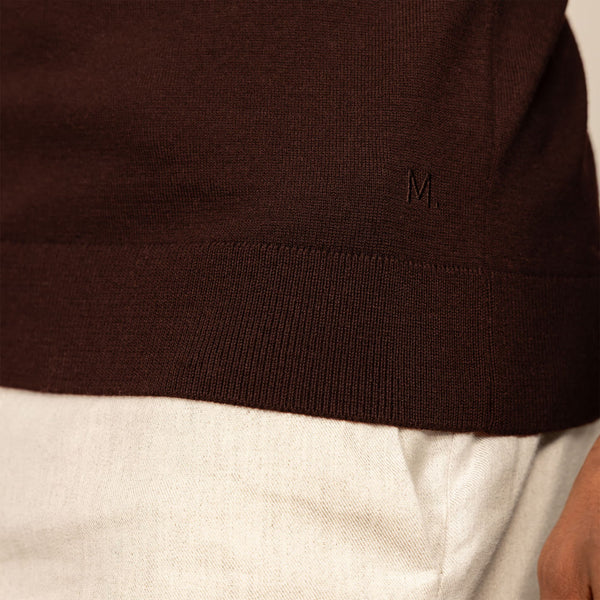 Man wearing a Marame Merino Cotton Long Sleeve Polo in Brown Cherry, closeup.