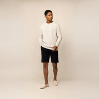 Man wearing a Marame Merino Wool Crew Neck Knit Jumper in Speckled Grey, front view.