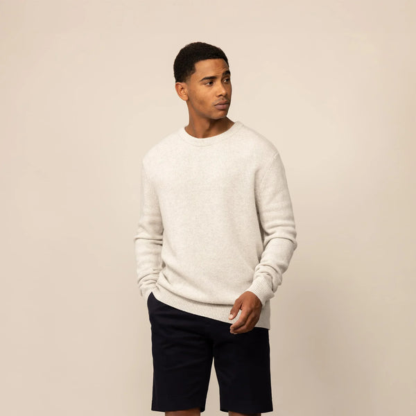 Man wearing a Marame Merino Wool Crew Neck Knit Jumper in Speckled Grey, front view.