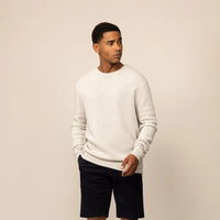 Man wearing a Marame Merino Wool Crew Neck Knit Jumper in Speckled Grey, front view.