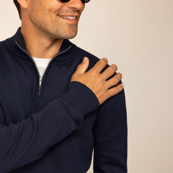 Man wearing a navy half zip jumper, closeup