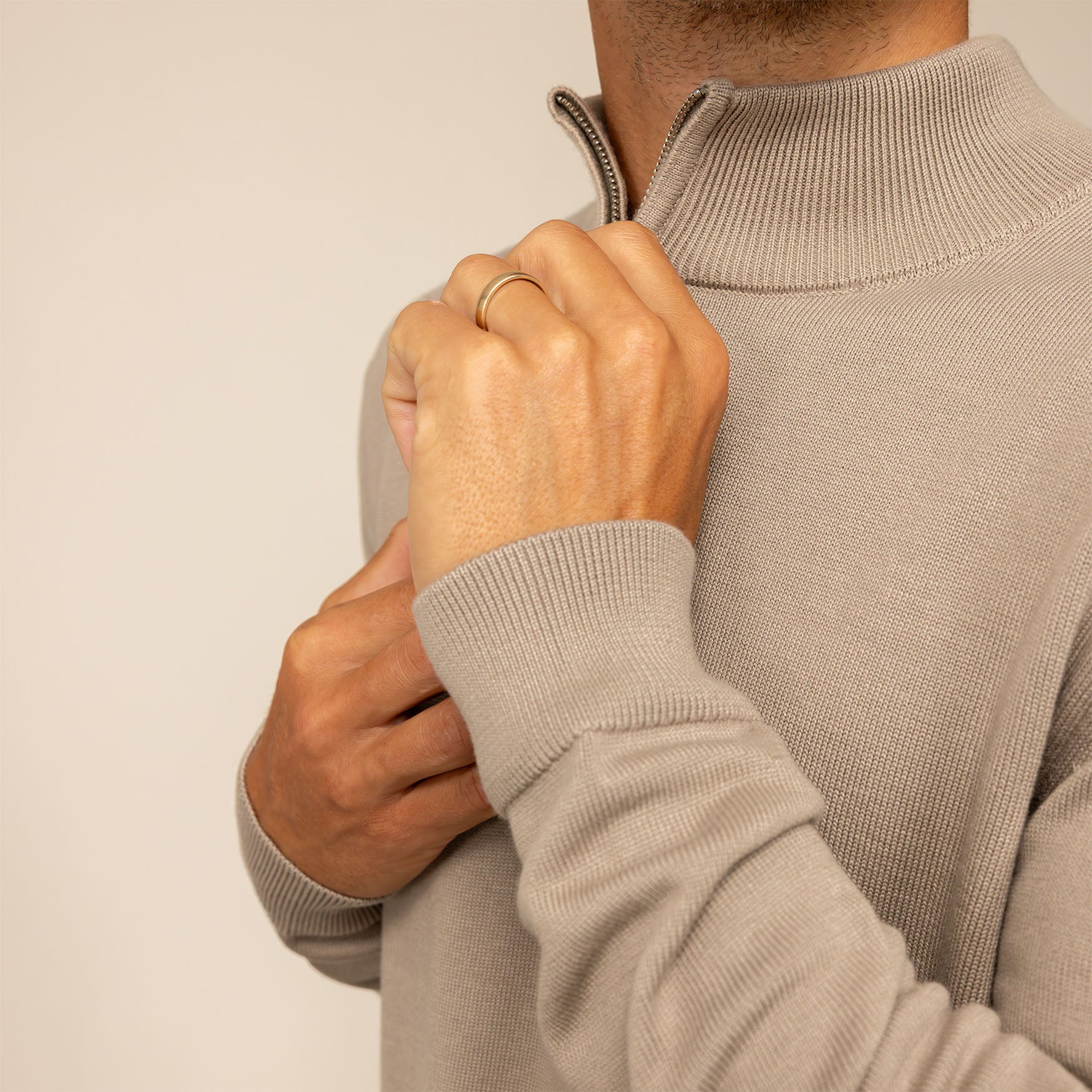 Man wearing a putty dove half zip jumper, closeup.