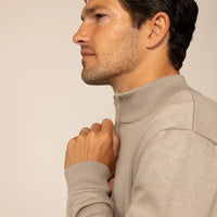 Man wearing a putty dove half zip jumper, side view.