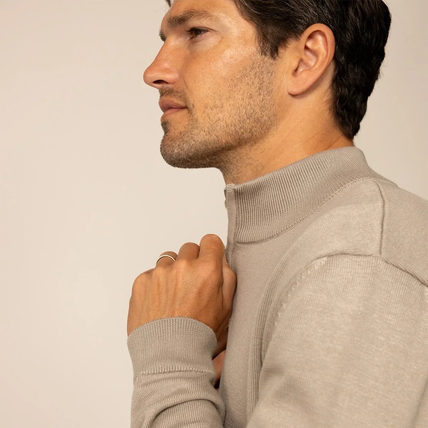 Man wearing a putty dove half zip jumper, side view. |putty dove