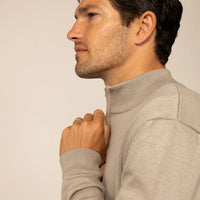 Man wearing a putty dove half zip jumper, side view. |putty dove