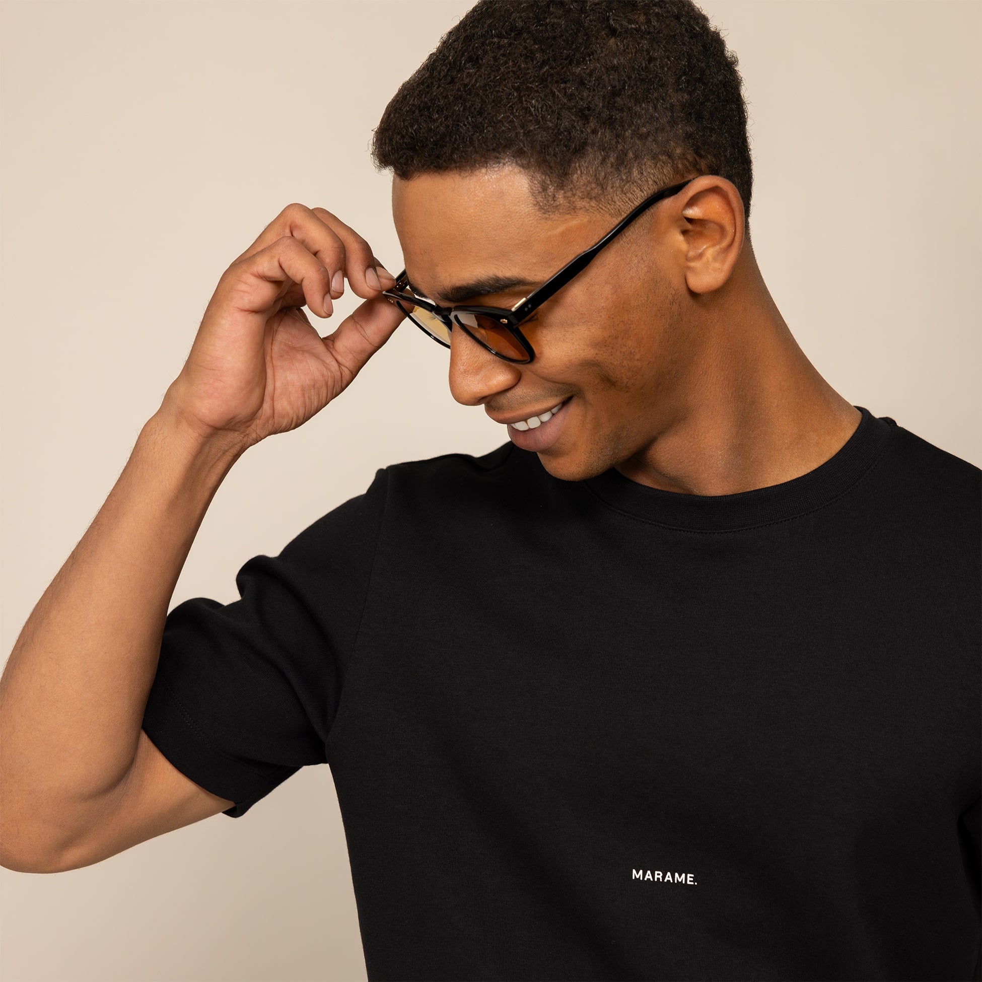Man wearing a Marame Relaxed Fit Logo T-Shirt in Black, closeup.