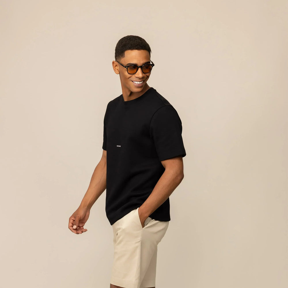 Man wearing a Marame Relaxed Fit Logo T-Shirt in Black, front view.