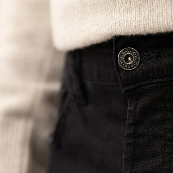 Man wearing Marame Slim Leg Denim Jeans in Black, closeup.