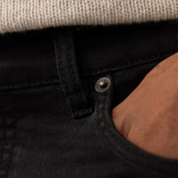 Man wearing Marame Slim Leg Denim Jeans in Black, closeup.