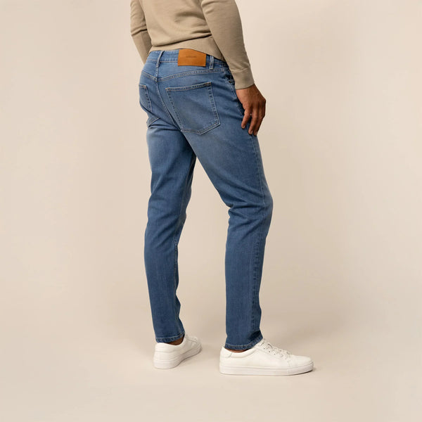 Man wearing Slim Leg Denim Jeans in Classic Wash, rear view.