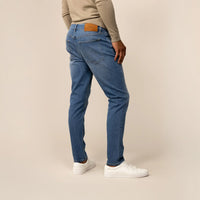 Man wearing Slim Leg Denim Jeans in Classic Wash, rear view.