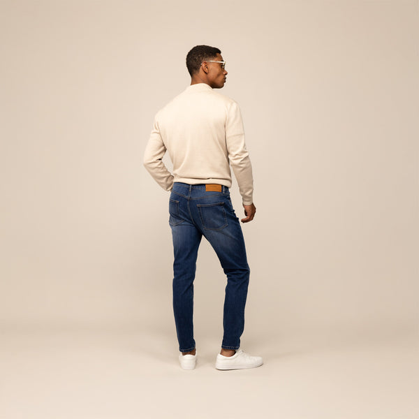 Man wearing Marame Slim Leg Denim Jeans in Deep Navy, rear view.