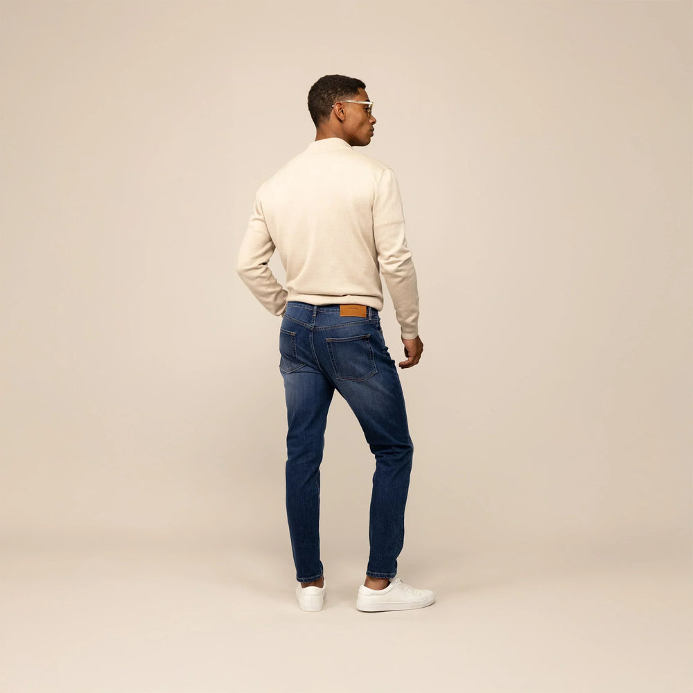 Man wearing Marame Slim Leg Denim Jeans in Deep Navy, rear view.