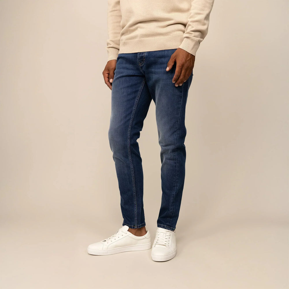 Man wearing Marame Slim Leg Denim Jeans in Deep Navy, front view.