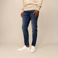Man wearing Marame Slim Leg Denim Jeans in Deep Navy, front view.