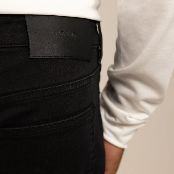 Man wearing Marame Straight Leg Denim Jeans in Black, closeup. |black denim