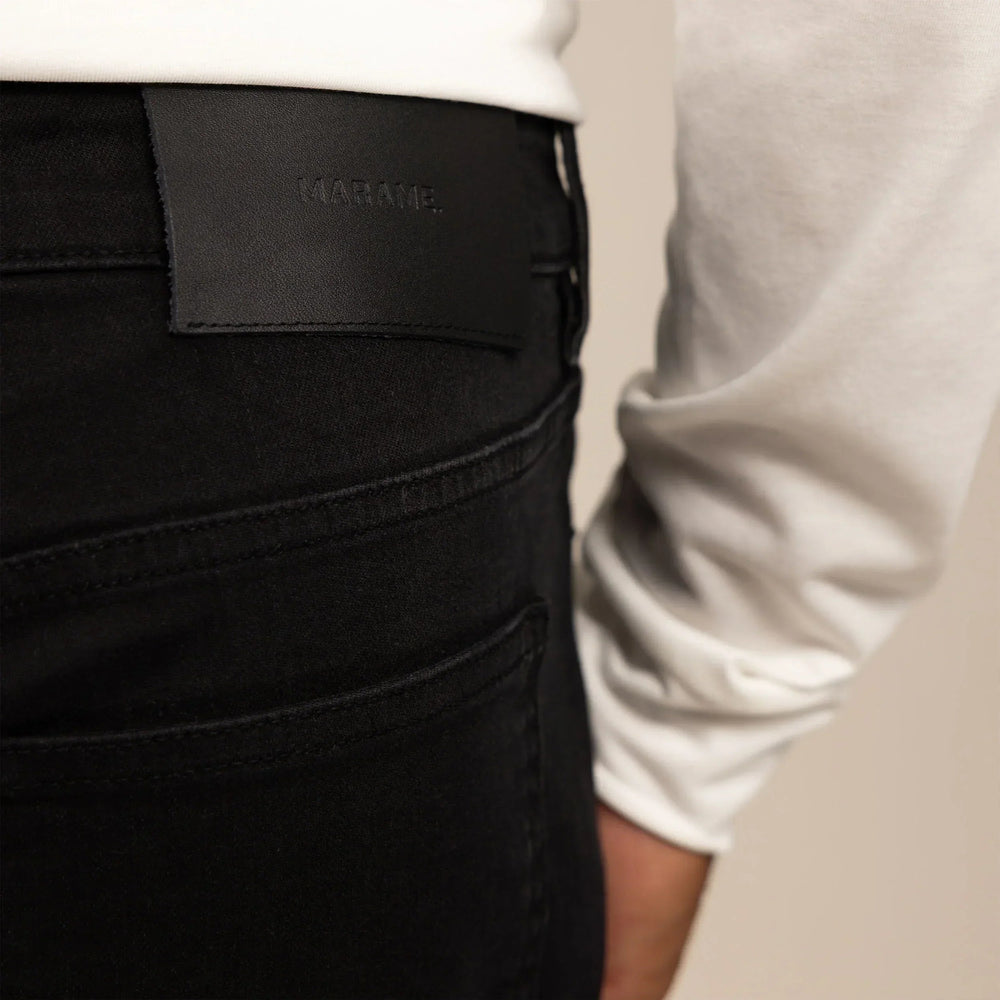 Man wearing Marame Straight Leg Denim Jeans in Black, closeup. |black denim