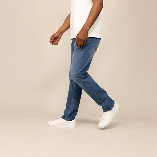 Man wearing Straight Leg Denim Jeans in Classic Wash, side view.