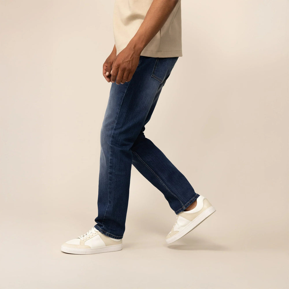Man wearing Marame Straight Leg Denim Jeans in Navy Wash, side view. |navy wash denim