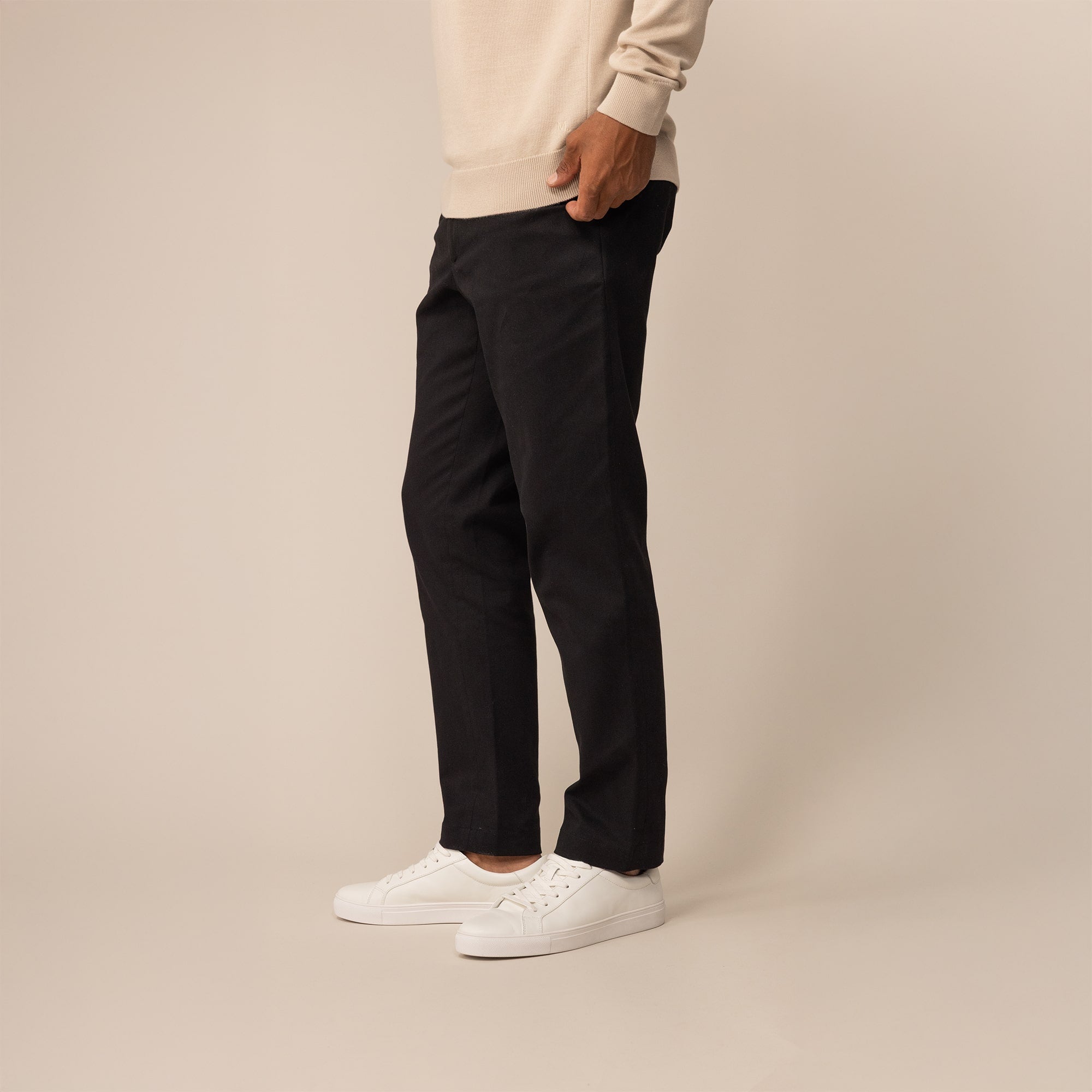 Man wearing Marame Tapered Chinos in Black, front view.
