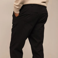 Man wearing Tapered Chinos in Black, rear view.