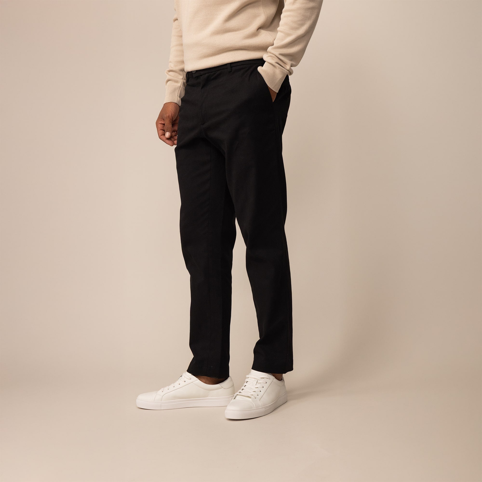 Man wearing Marame Tapered Chinos in Black, front view.