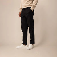 Man wearing Marame Tapered Chinos in Black, front view.