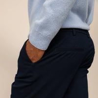Man wearing Marame Tapered Chinos in Navy, rear view.