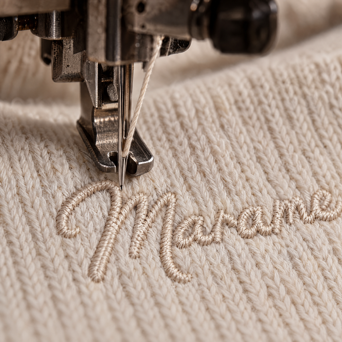 MARAME embroidery on a cream knit garment