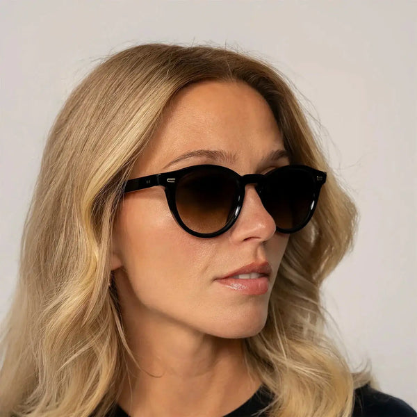Woman wearing Cutler and Gross Round Sunglasses 9378 in Black, front view.|black