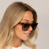 Woman wearing Cutler and Gross Square Sunglasses 1386 in Crystal Peach, front view.