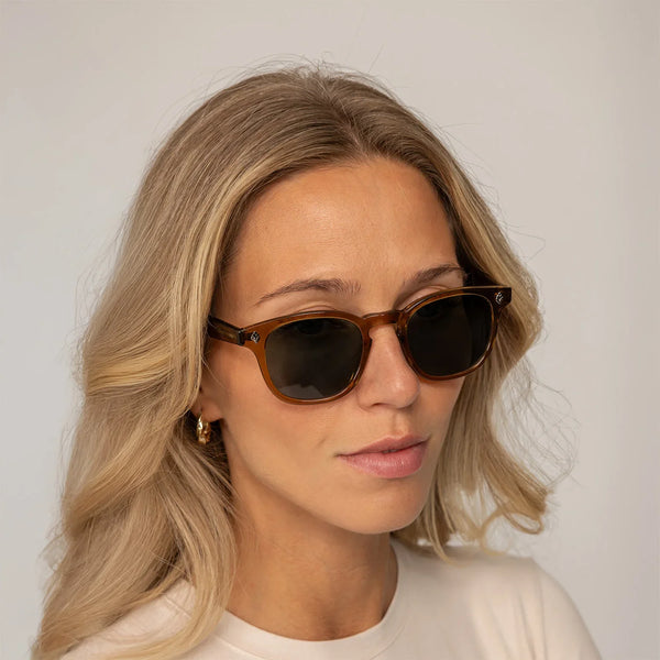 Womean wearing Garrett Leight Ace Sun Sunglasses in Caramel, front view.